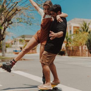 Happy Couple Experiencing Joy And Leisure While Skateboarding Together Outdoors In Rio De Janeiro.