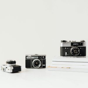 Three Vintage Cameras Displayed On A White Background, Emphasizing Nostalgia And Retro Design.