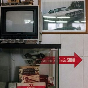 A Vintage Car Collection In A Garage With A Classic TV And Framed Photograph Decor.