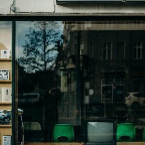 Reflection Of A City Street In A Shop Window Showcasing A Vintage Television.