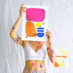 Bright Abstract Art Piece Held By Decorated Woman, Embracing Creativity.