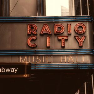 Vintage Neon Sign Of Radio City Music Hall In An Urban Atmosphere, Evoking Retro Charm.