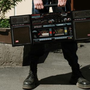 A Person Holding A Vintage Boombox Outdoors On A Sunny Day.