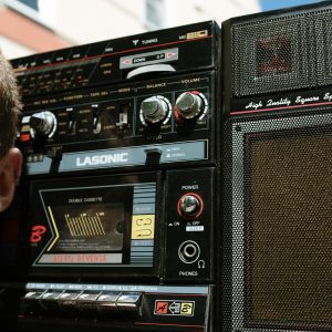 Close Up Of A Vintage Boombox Stereo Held Outdoors, Evoking Nostalgic Music Vibes.