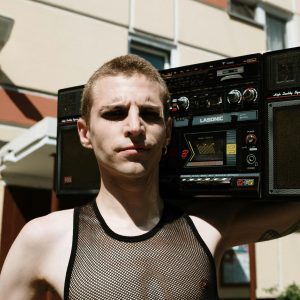 Portrait Of A Man Holding A Vintage Boombox Outdoors In A Suburban Area.