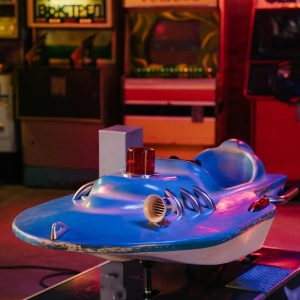A Vintage Coin Operated Spaceship Ride In A Nostalgic 80s Arcade Setting.