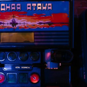 Close Up Of Vintage Arcade Machine Lit By Neon Lights, Featuring Cyrillic Lettering.