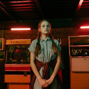 Teenage Girl With Pigtails In An Arcade Setting With Neon Lighting And Vintage Games.