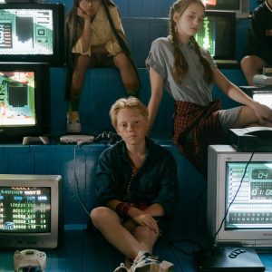 Group Of Teenagers Enjoying Classic Video Games In A Vintage Arcade Setting.