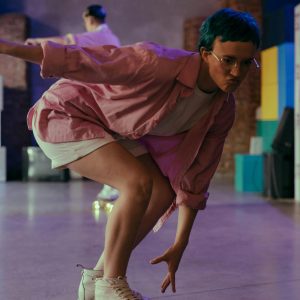 Teenager With Colored Hair Skateboarding Indoors, Showcasing Fun And Freedom.