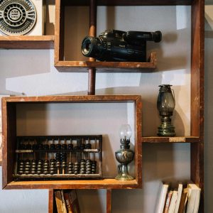 A Stylish Vintage Wooden Shelf With Retro Camera, Books, And Antique Items For Unique Decor.