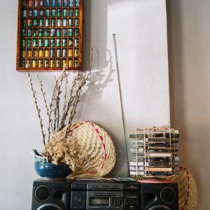 A Classic Boombox With Cassette Tapes, Dried Flowers, And Roll Films Creates A Nostalgic Vintage Setting.