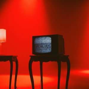 Retro TV Displaying Static On Wooden Table Under Dramatic Red Lighting.