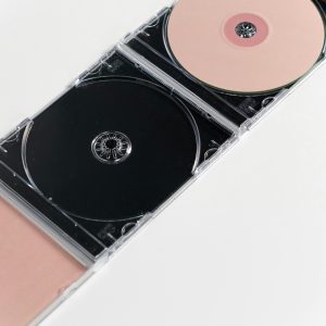 Artistic Flat Lay Of Open CD Cases On A White Surface, Showcasing Compact Discs.