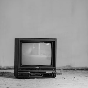 Black And White Vintage TV On A Concrete Floor, Conveying Nostalgia And Abandonment.