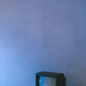 A Nostalgic Vintage Television Set Against A Textured Blue Wall, Ideal For Retro Themes.