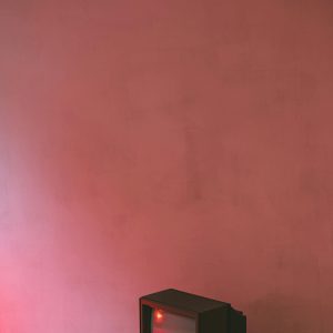 Small Retro TV Set With Plastic Case And CRT Glass On Cement Floor Near Wall In Building