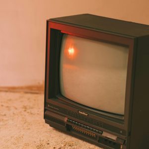 Old Fashioned Television Set With Cathode Ray Tube Display On Rough Floor In House
