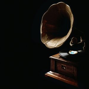 A Classic Gramophone With Vinyl Record, Showcasing Vintage Charm In A Dark Ambiance.