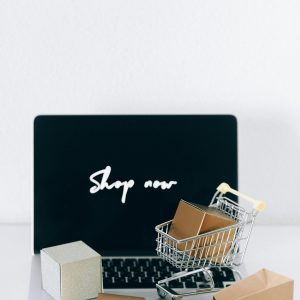 Minimalist Online Shopping Setup With Laptop, Cart, And Packages Symbolizing E Commerce.