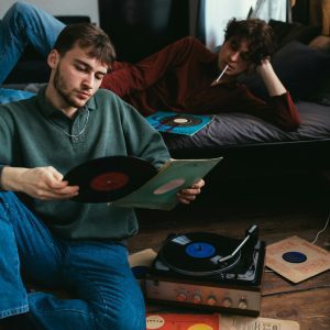 Two Young Adults Enjoying Vinyl Records In A Cozy, Vintage Style Room.