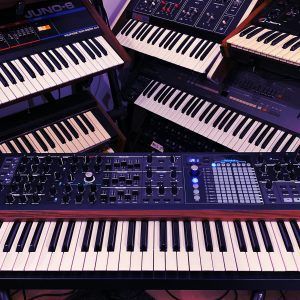 Explore A Collection Of Vintage And Modern Electronic Synthesizers In A Studio Setting. Perfect For Music Production Enthusiasts.