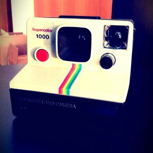 A Close Up Of A Retro Polaroid Camera On A Table With A Modern Touch.