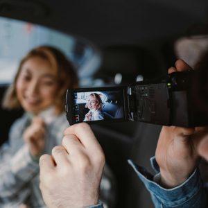 A Couple Enjoys Filming A Candid Moment Together Inside A Car.