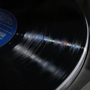 Detailed Close Up Of A Spinning Vinyl Record Showing Grooves And Reflections.
