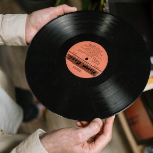 Close Up Of Hands Holding A Vintage Vinyl Record Indoors.