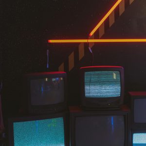 Vintage Televisions Display Static In A Dark Room Accented By Bright Neon Lights.