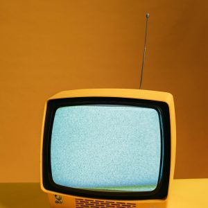 Retro Yellow Television On Orange Backdrop With Static Screen, Perfect For Vintage Themes.