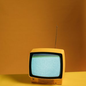 Vintage Yellow Television With Static Screen On An Orange Backdrop Creating A Nostalgic Vibe.