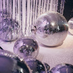 Glistening Disco Balls With Metallic Streamers Create A Retro Party Vibe Indoors.