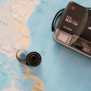 Film Camera On World Map, Symbolizing Travel And Exploration.