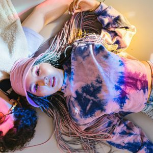 Friends Enjoying Casual Time Together In Colorful Tie Dye Fashion. Shot Indoors With A Playful, Vibrant Mood.