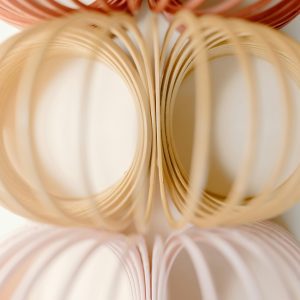 Stylized Photo Of Pastel Slinkies Arranged In A Geometric Pattern, Exuding Nostalgia And Playfulness.