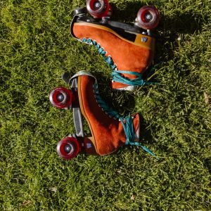 Colorful Vintage Roller Skates Placed On Vibrant Green Grass In Bright Sunlight.