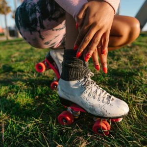 Close Up Of A Woman Enjoying Leisure Time On Roller Skates In A Sunny Park Setting.