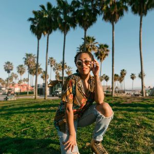 Stylish Young Woman Roller Skating Outdoors Under Sunny Palm Trees.