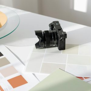 Digital Camera Resting On A Desk With Color Swatches And Design Materials.