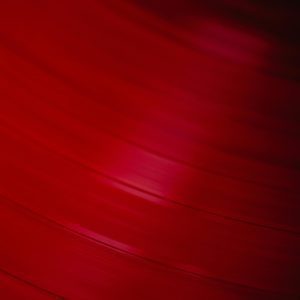 Abstract Close Up Of Red Vinyl Record With Grooves Visible. Perfect For Music Themed Projects.