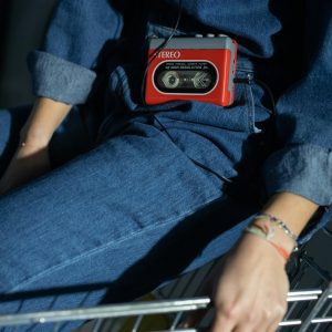 Close Up Of A Person In Denim Wearing A Retro Cassette Player, Capturing Vintage Fashion Vibes.