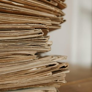 Close Up Of Vintage Paper Stacks On A Wooden Table, Evoking A Classic Office Setting.