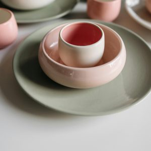 A Minimalist Arrangement Of Pastel Ceramic Dishware Including Bowls And Plates.