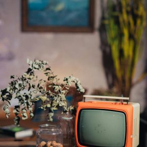 Retro Orange TV With Rustic Decor, Indoor Setting, Evokes A Vintage Feel.