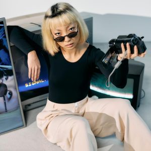 Chic Fashion Model Poses With Retro Electronics In A Stylish Studio Setup.