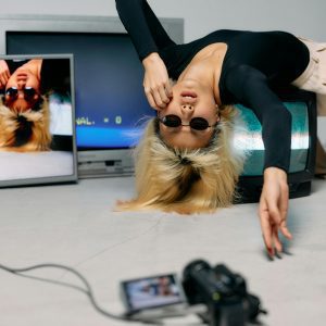 Stylish Model Posing With Retro TVs And Camera In An Artistic Fashion Shoot.
