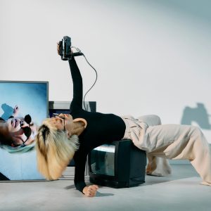 Stylish Woman Posing With Vintage CRTs In A Modern Editorial Photoshoot.