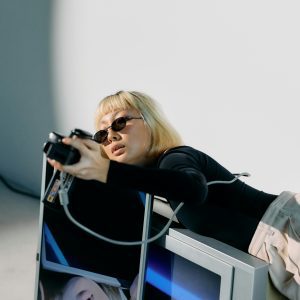 Chic Fashion Model Posing With Vintage Tech In A Conceptual Studio Shoot.